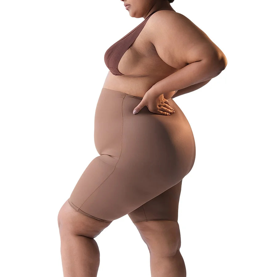 Curvy woman modeling "Shorty" bodysuit shorts in brown.