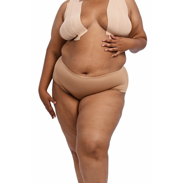 Plus-size model showcasing the "Cheeky" shapewear set in nude.